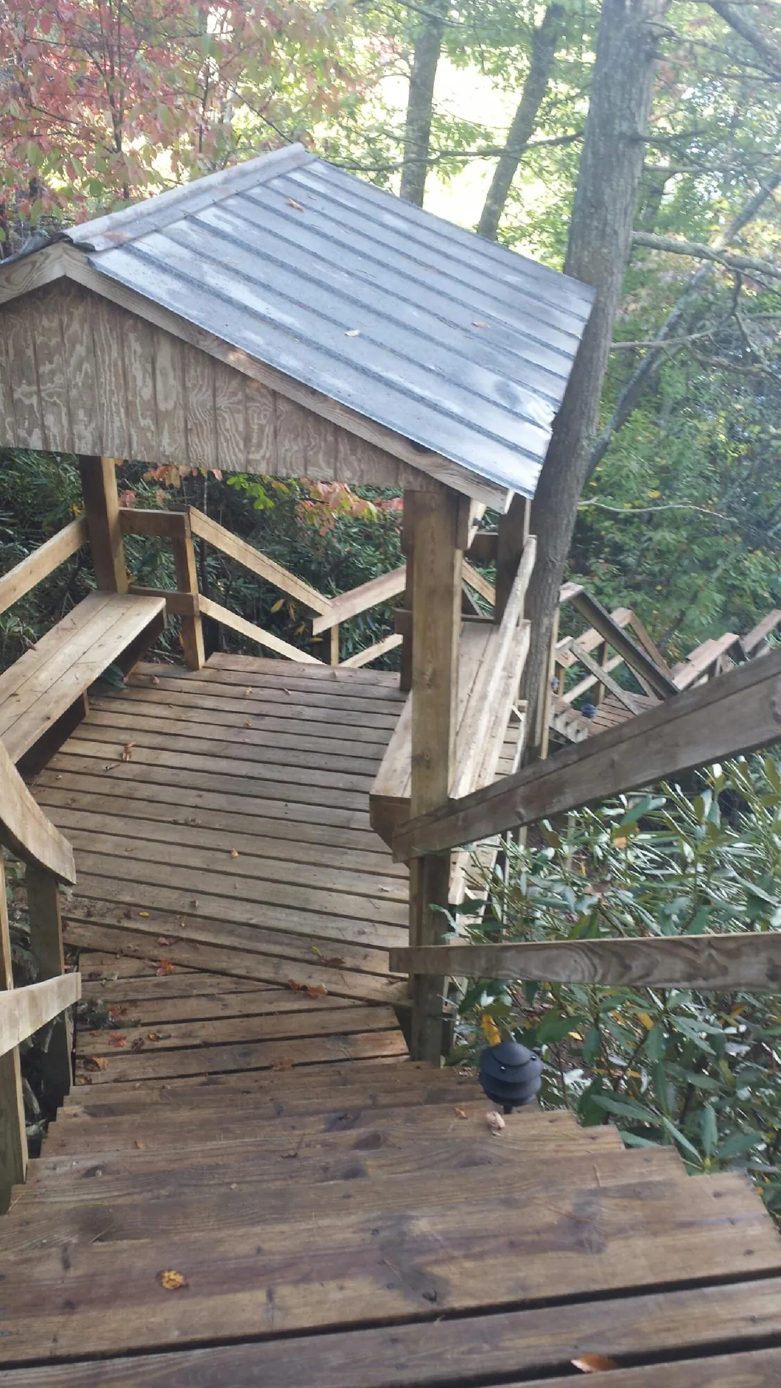 Metal roofed shelter over wooden steps on a wooded walkway — Skylight Repair & Installation work by our crew in Ashburnham